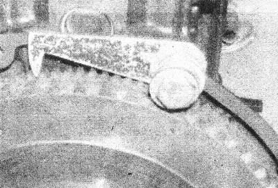 16.8 Using a suitable tool, lock the flywheel from rotating.