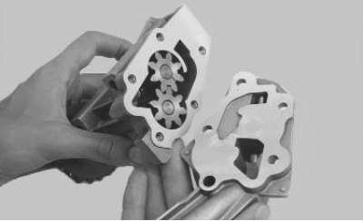 3. Выверните пять винтов крепления крышки масляного насоса...